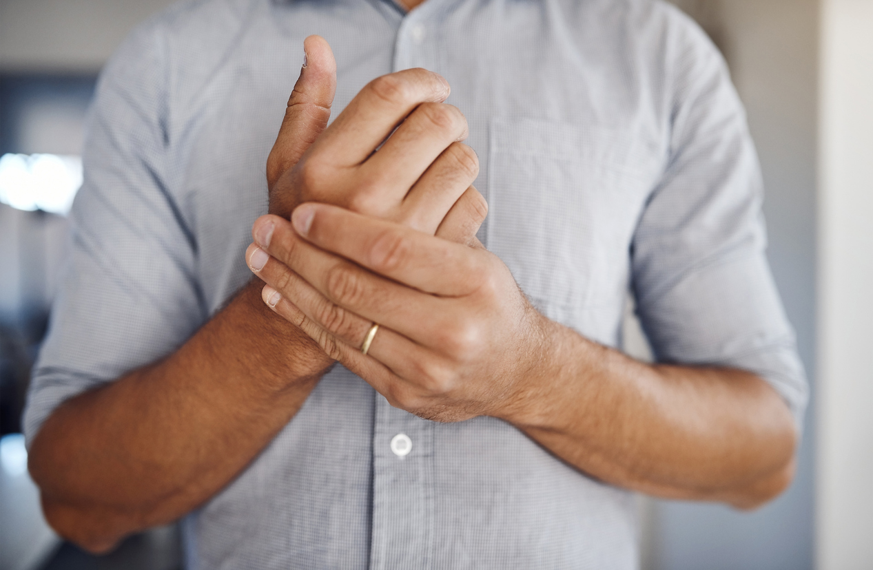 man holding wrist in pain while at home