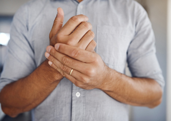 man holding wrist in pain while at home