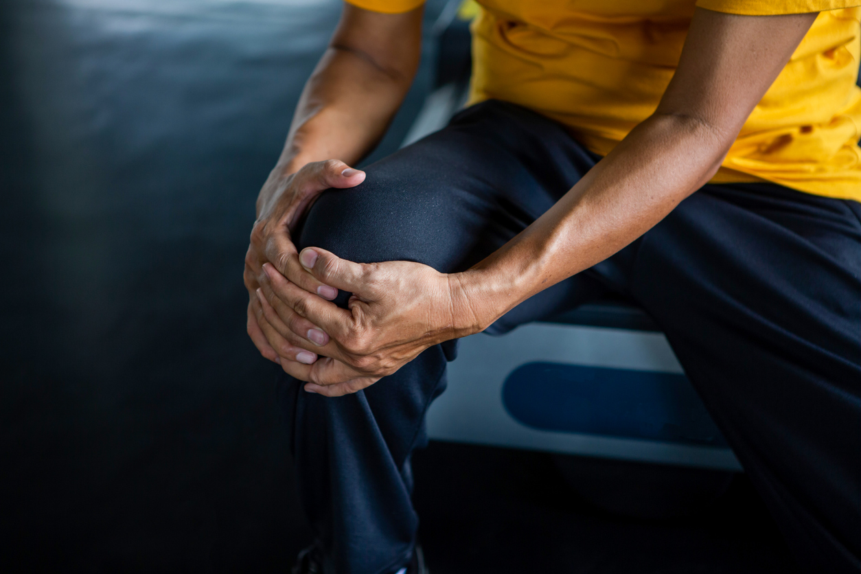 man holding knee in pain