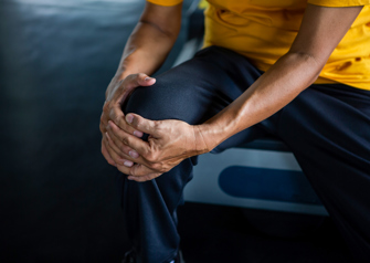 man holding knee in pain