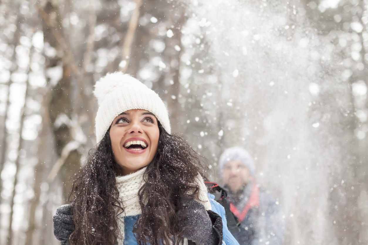 Cheerful young woman having fun in the snow forest stock photo