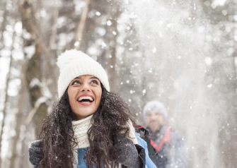 Cheerful young woman having fun in the snow forest stock photo