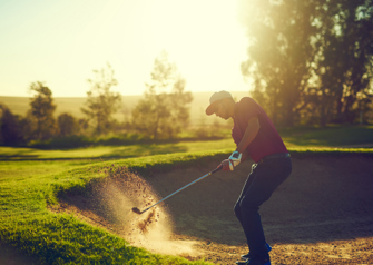 golfer chipping out of bunker