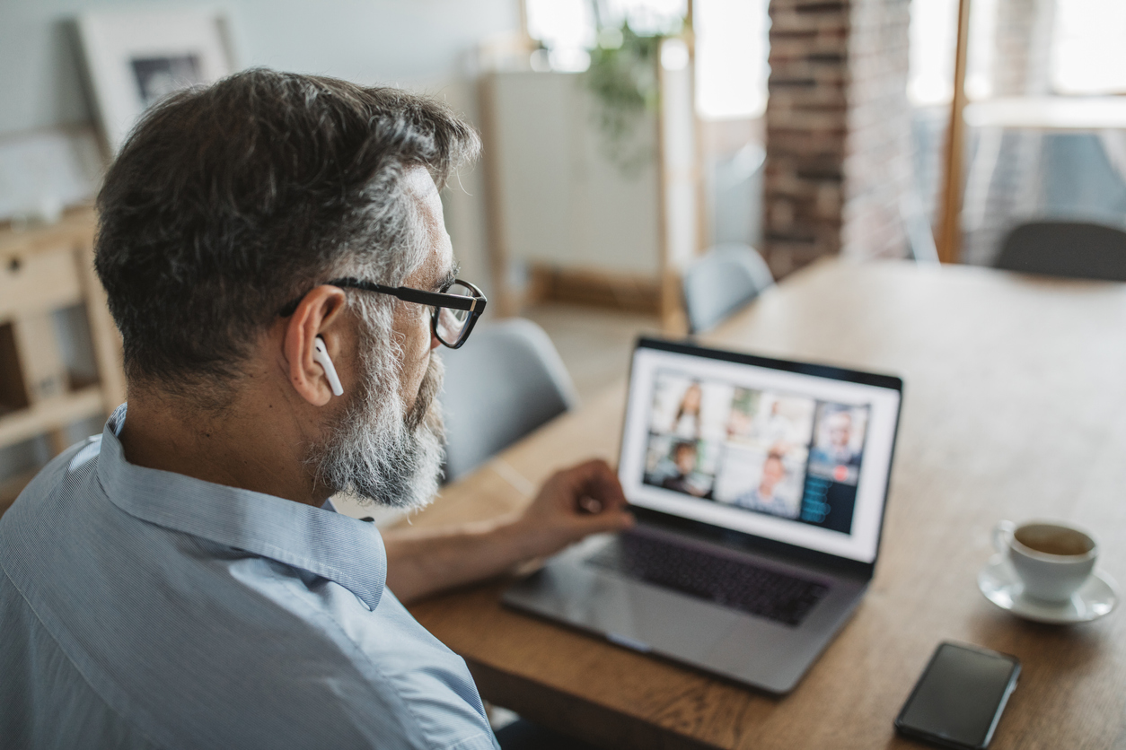 man working from his home on conference call with computer