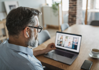 man working from his home on conference call with computer