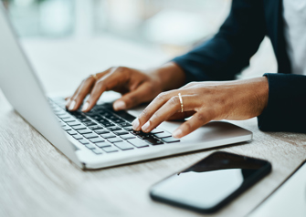 Shot of an unrecognisable businesswoman using a laptop in a modern office