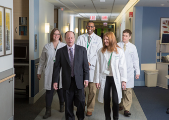 Dr. Goldberg walking in hallway with clinical staff