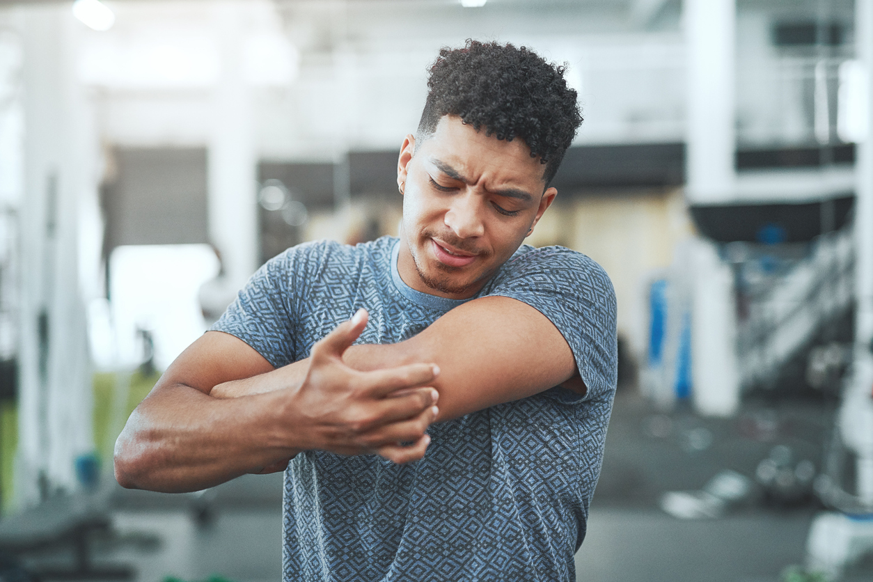 Man touching elbow in pain